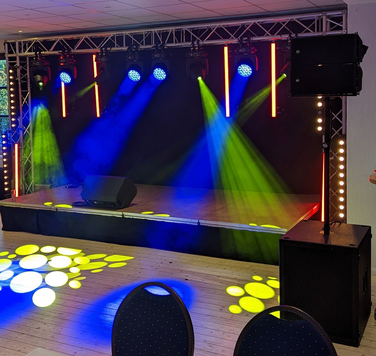 Bühne mit Traversen, Moving Lights und Gobo-Projektionen auf der Tanzfläche