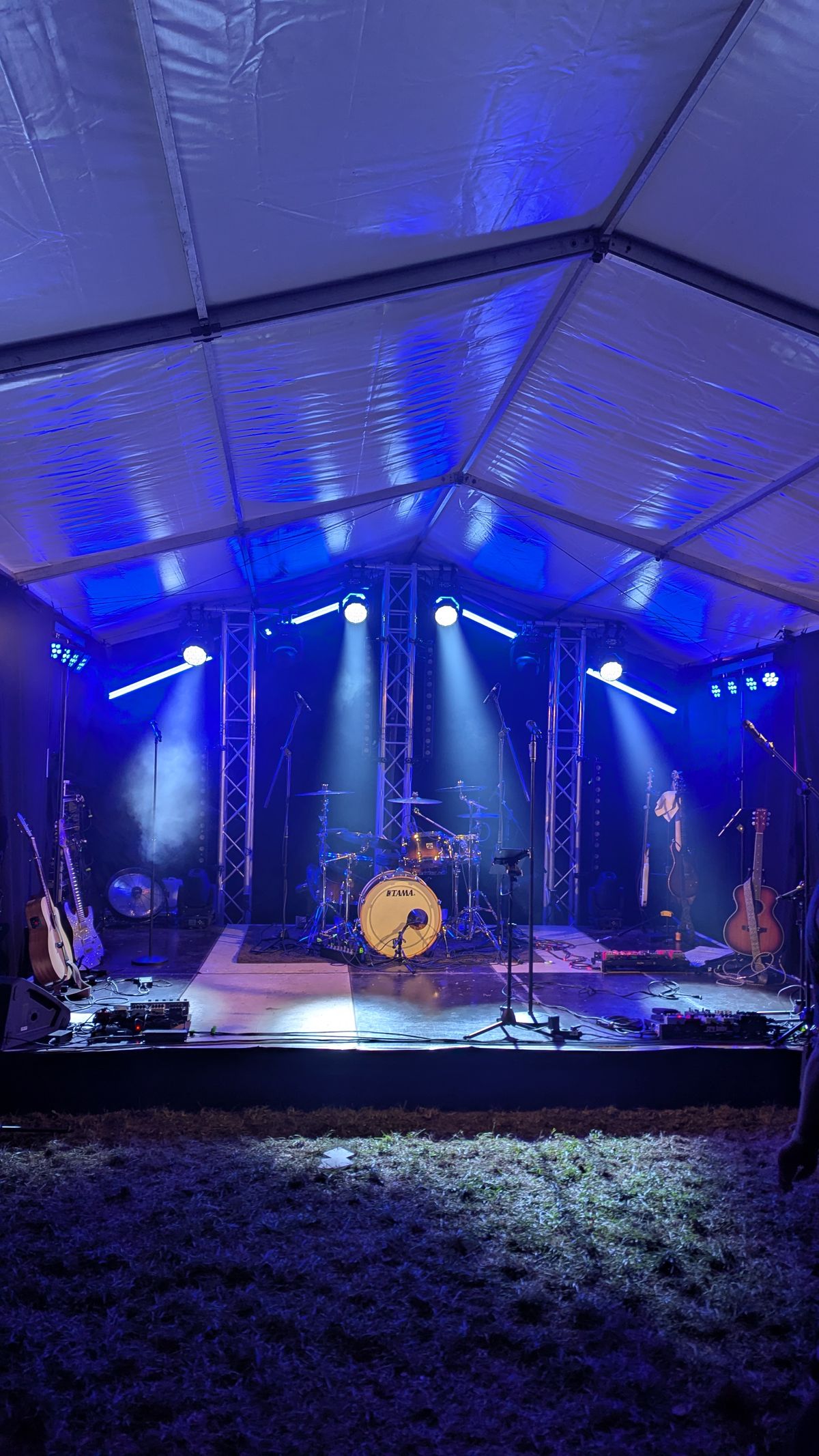 Blau ausgeleuchtete Bühne in einem Festzelt mit Live-Equipment